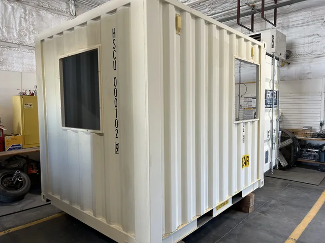 Generator housing container with integrated fuel storage compartment