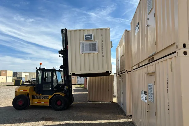 Container with open doors displaying the plywood floor and cargo space