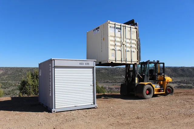 Nighttime photo of a lit container office at a construction site