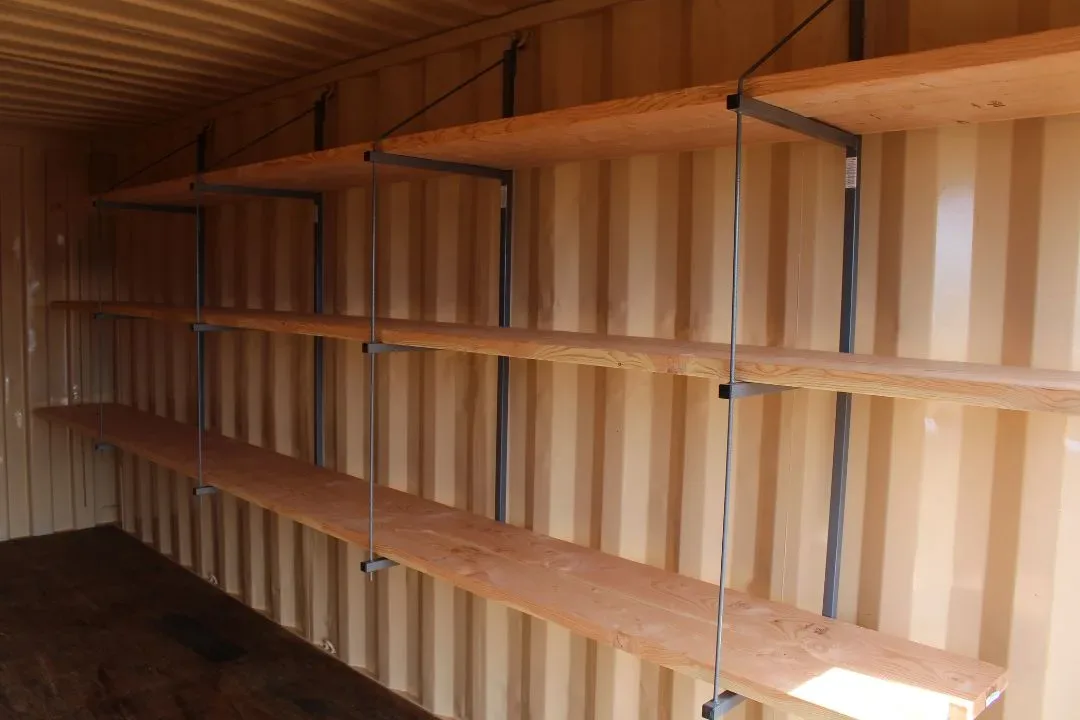 Same container interior now fitted with three tiers of heavy-duty wood shelving mounted on steel brackets
